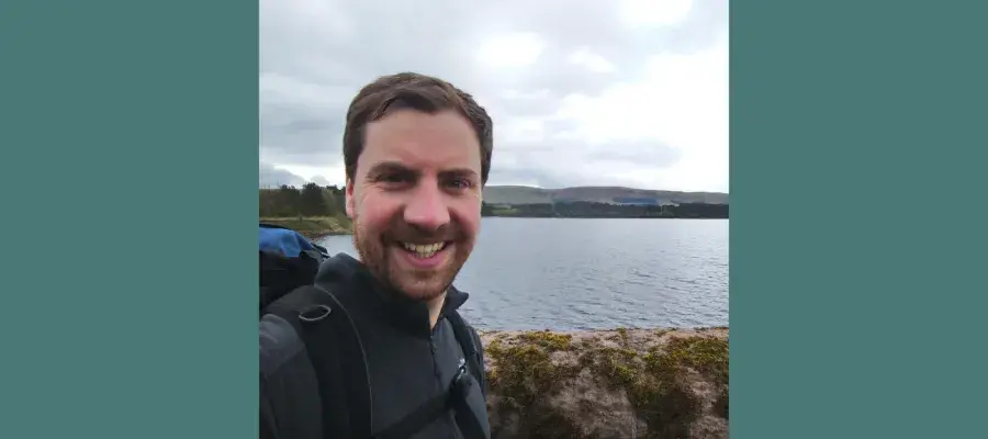 Alumnus David August with a loch in the background