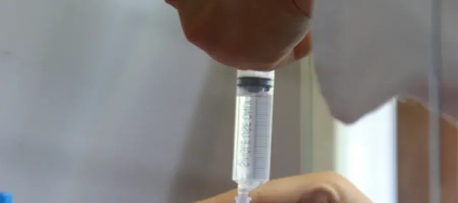 Scientist filtering solution through a syringe filter