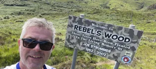 Colin Campbell next to a sign for Rebel's Wood