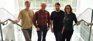 Four members of the Horrocks Group posing on stairs