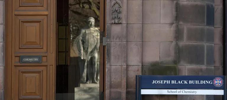 A statue reflected in a doorway