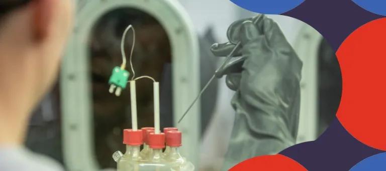 Scientific glassware with blurred operator