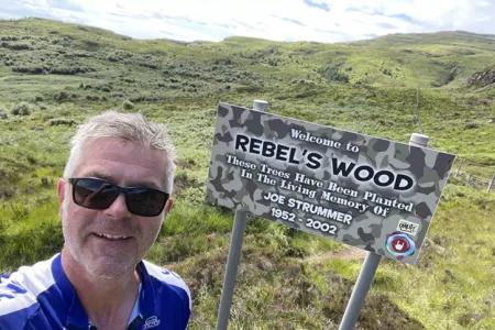 Colin Campbell next to a sign for Rebel's Wood