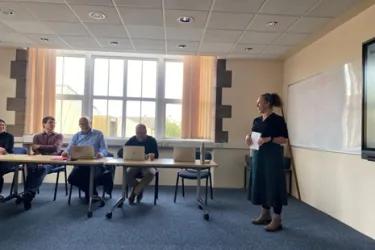 Picture of Jenni Garden in front of a group of academics from the School of Chemistry