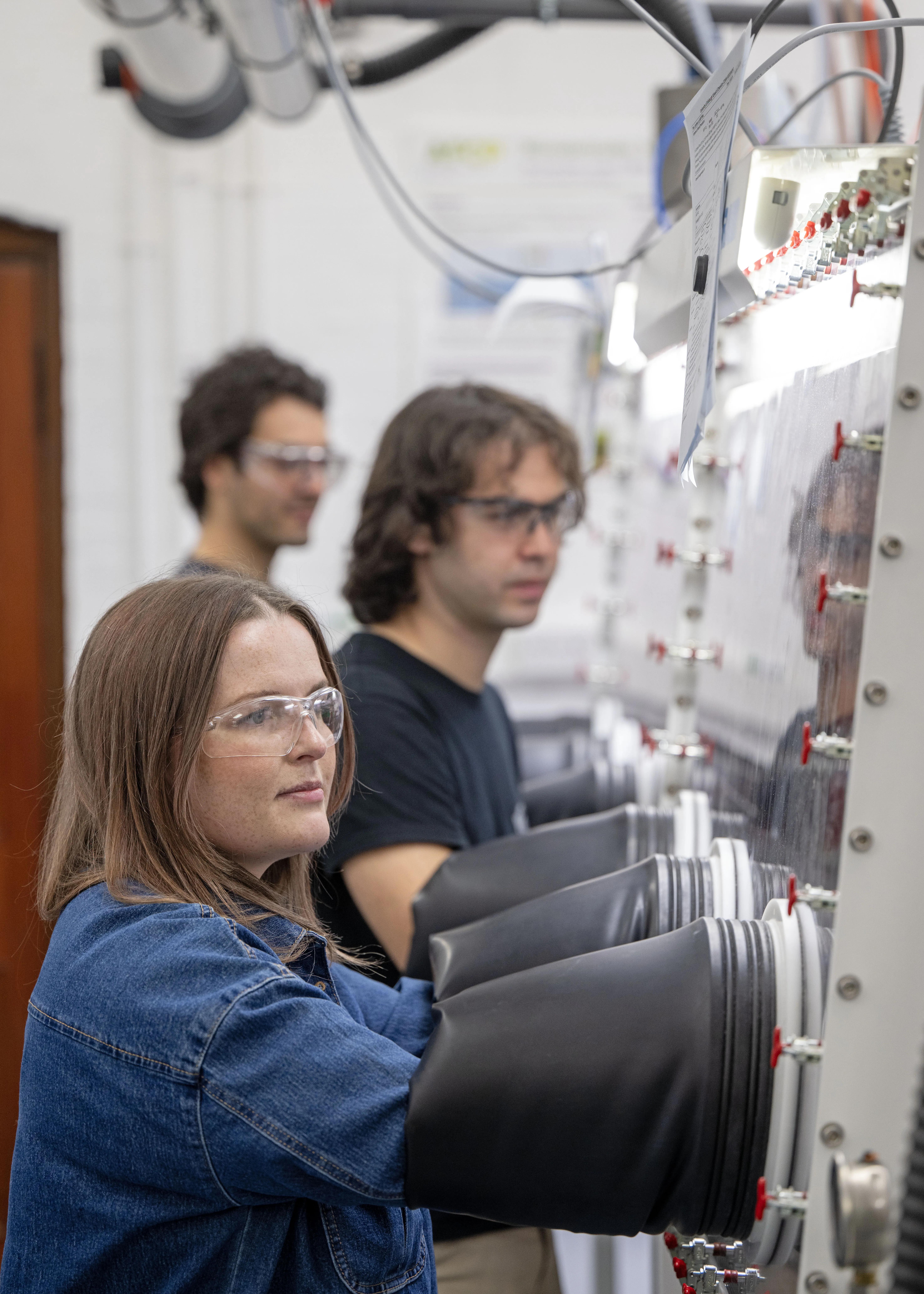 Members of the Pyrochemical Research Laboratory doing work in glove boxes.